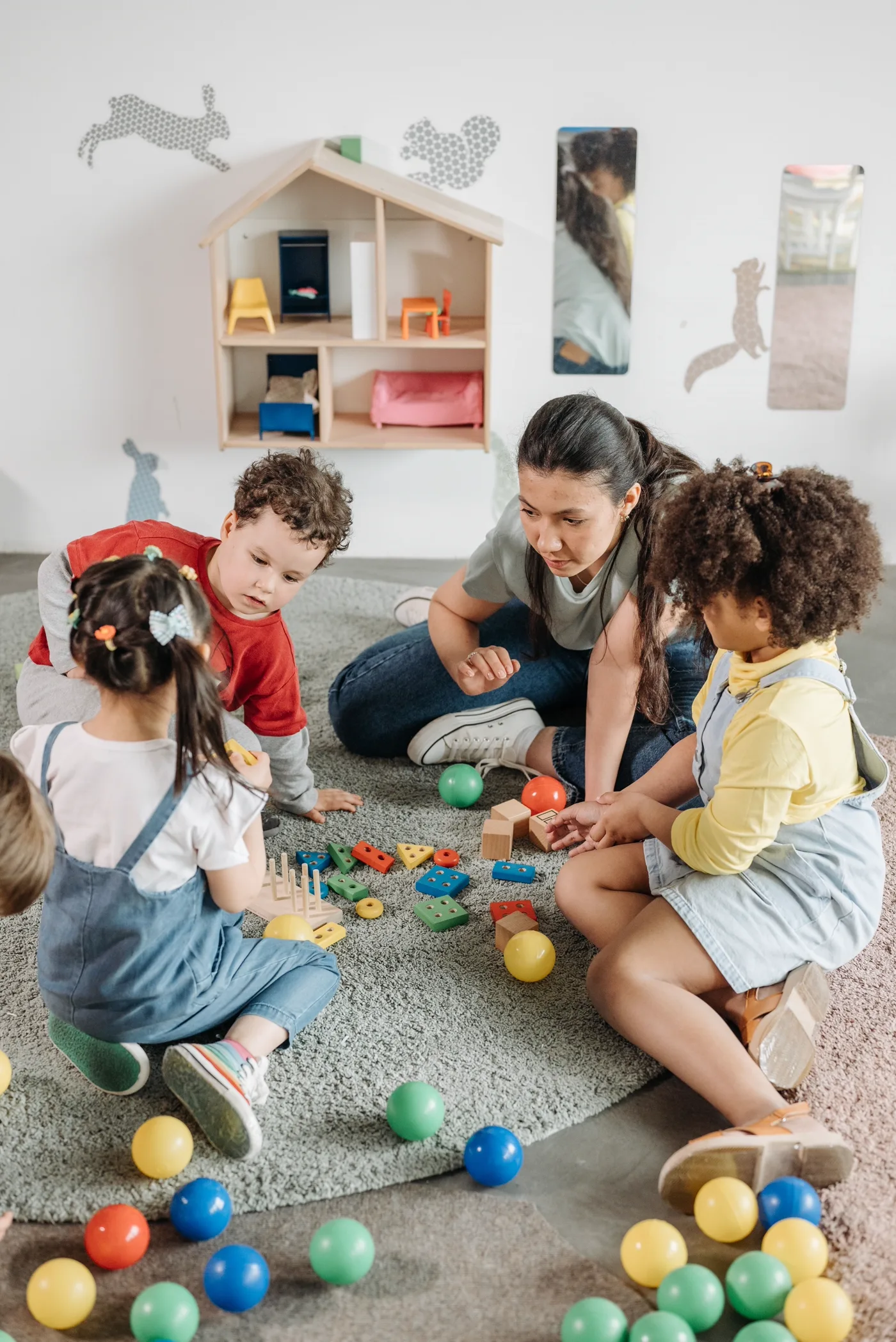 A caregiver playing warmly with children in the nursery