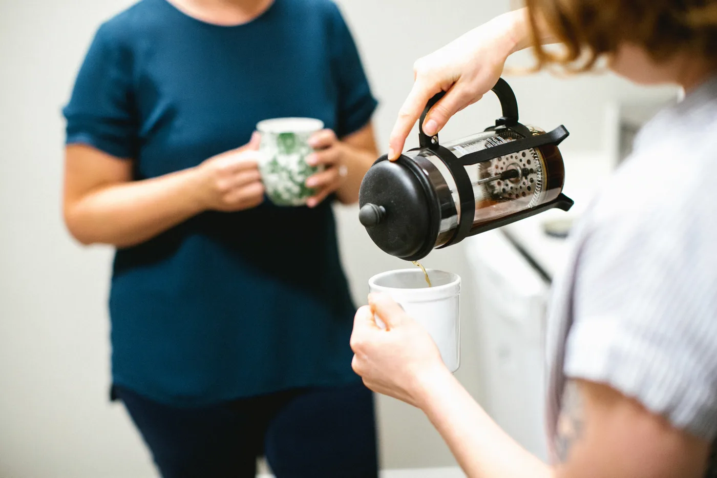 A volunteer pouring coffee for another church member during fellowship after the service