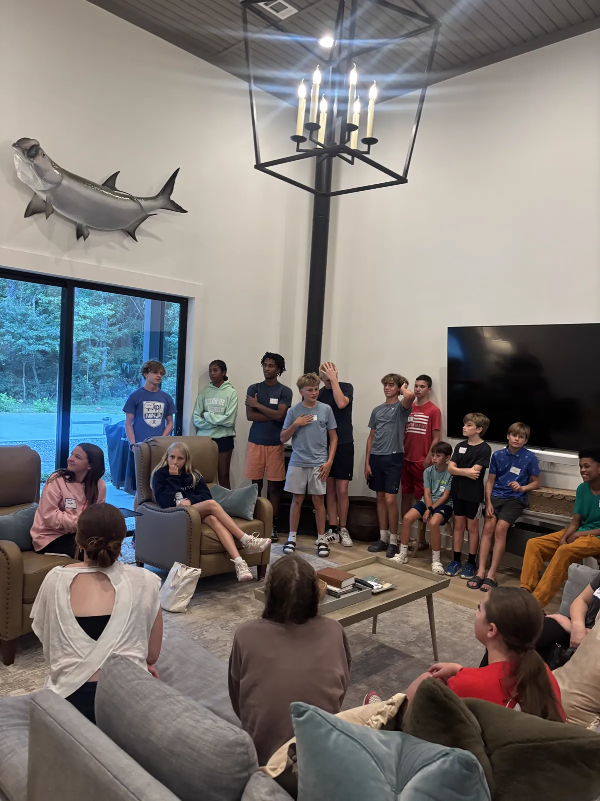 Kids and teens gathered together in a living room at the Youth Fall Kickoff